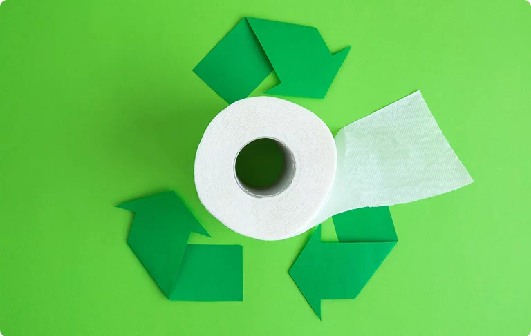 rolka papieru toaletowego na tle znaków recyklingu